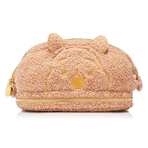Two-tier Boucle Textured Makeup Bag - £29.99. The Winnie The Pooh makeup bag is complete with Winnie appliqué that’s like a cuddle for your cosmetics! The two-tier design has a large compartment for all your makeup must-haves and a smaller zipped compartment with an elasticated pocked for you all important brushes.
